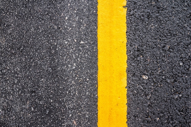 Asphalt road surface with yellow line