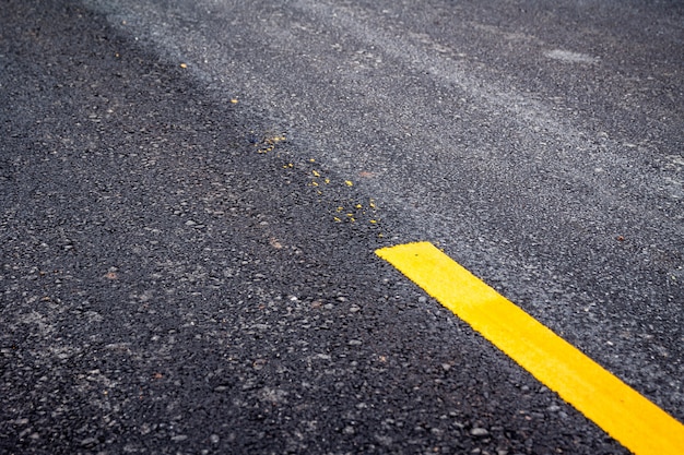 Asphalt road surface with yellow line