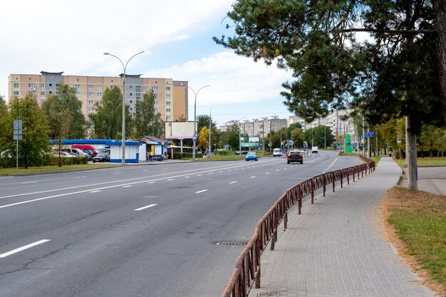 Асфальтированная улица с транспортом в жилом районе города среди многоэтажных зданий