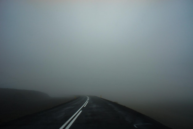 Asphalt wet road and thick fog. Space for text landscape scenery