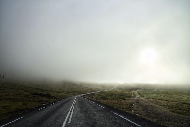 Photo asphalted countryside road under the misty sky