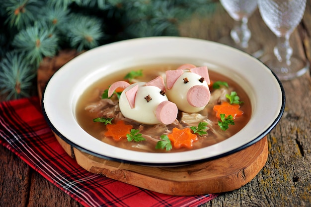 Aspic met vlees, varkensgelei is een feestelijk traditioneel Russisch gerecht versierd met gekookte eieren in de vorm van schattige varkens.