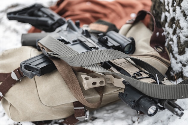 Photo an assault rifle lies on a military briefcase in winter time.