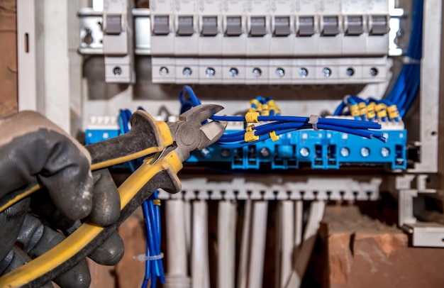 the Assembly of the electrical panel, electrician job, a robot with wires and circuit breakers