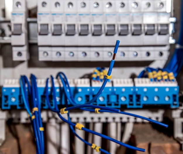 the Assembly of the electrical panel, electrician job, a robot with wires and circuit breakers