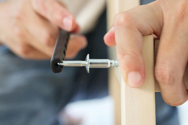 Foto assemblaggio mobili in legno a casa usando la vite a brugola