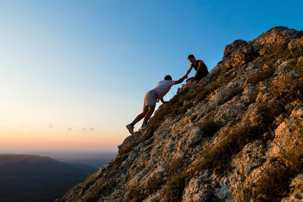 Assistance rock climbing mountain teamwork challenge adventure sunset