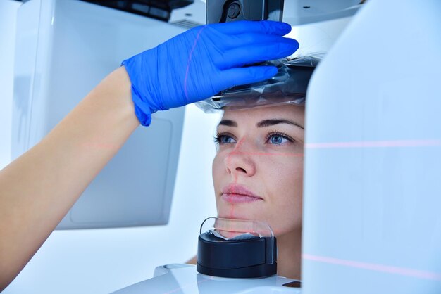 Фото Ассистент устанавливает компьютерный томограф на голову пациента