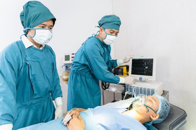 L'assistente chirurgo ha messo il paziente su una maschera di ossigeno ventilato in preparazione per l'intervento chirurgico