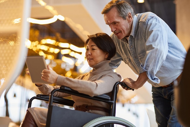 Assisting Asian wife in wheelchair