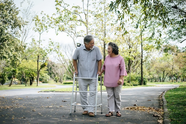 assisting her senior patient who's using a walker for support