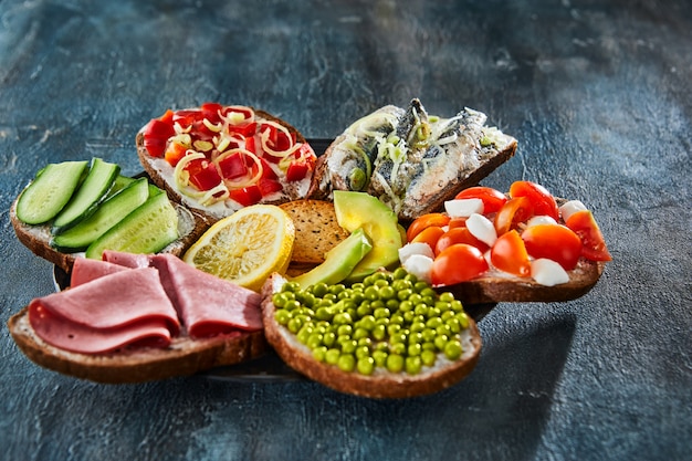 Assorted appetizers on dark table