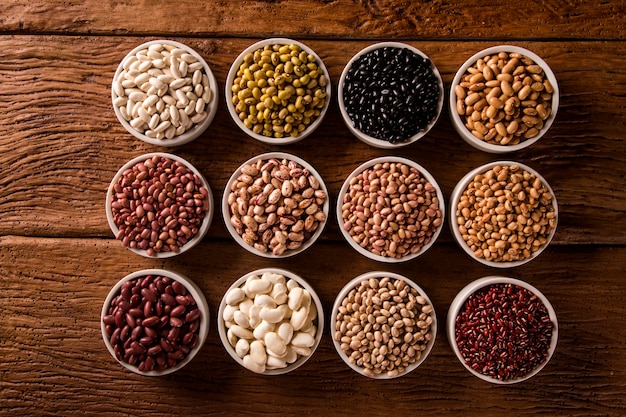 Assorted beans in bowls on wooden table