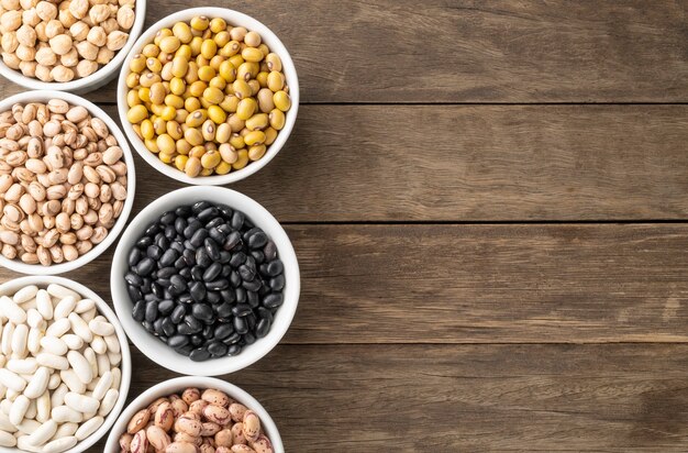 Photo assorted beans on white bowls with copy space.