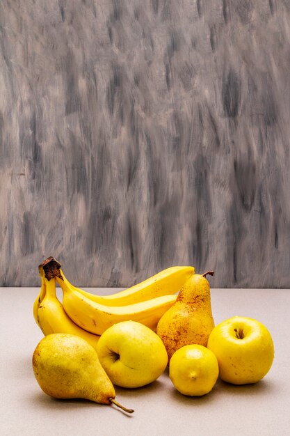 Assorted bright yellow fruits. Fresh banana, pear, apple, lemon.