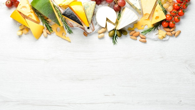 Assorted cheese and snacks on white wooden background Dairy products Top view Free space for your text