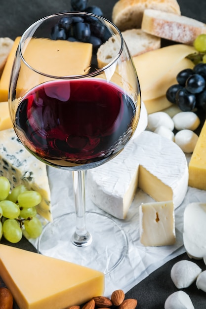 Assorted cheeses, soft, hard, rennet and brine, and a glass of red wine