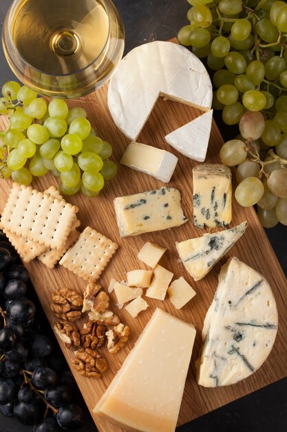 Assorted cheeses with white grapes.