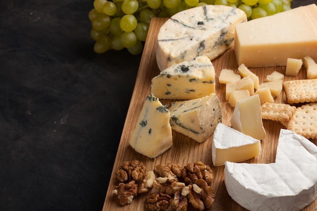 Assorted cheeses with white grapes.