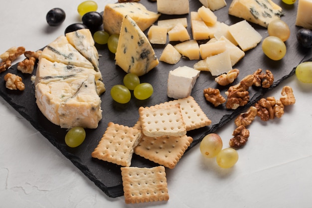 Assorted cheeses with white grapes.