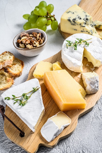 Assorted cheeses on a wooden cutting Board.