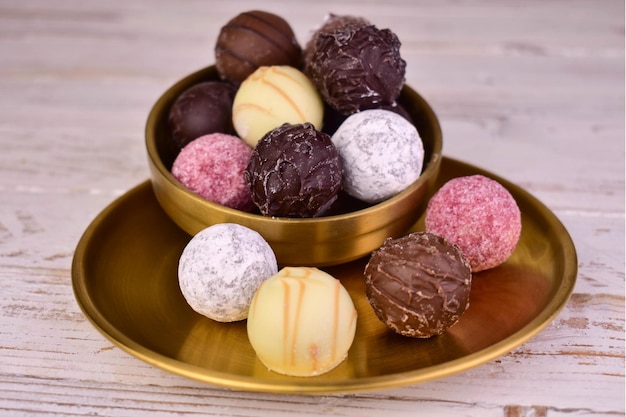 Ассорти шоколадных конфет в форме шарика на тарелкеКрупным планом