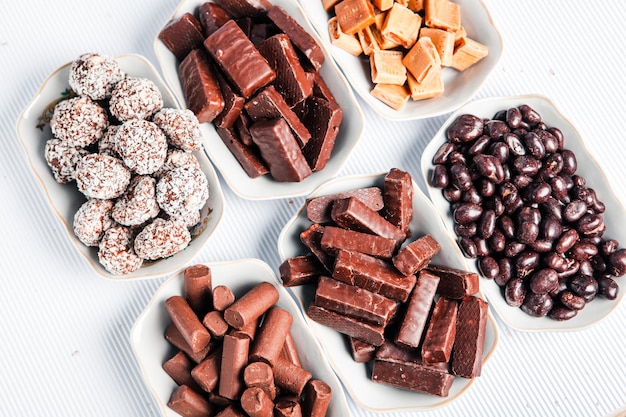 Assorted chocolate candies on wooden background