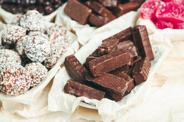 Assorted chocolate candies on wooden background