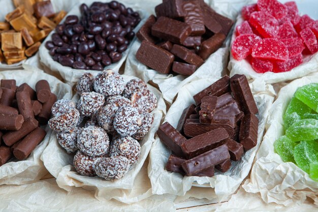 Assorted chocolate candies on wooden background