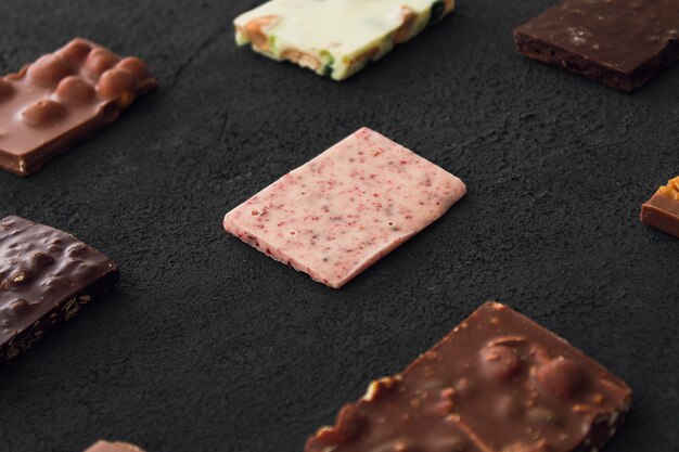 Assorted chocolate pieces on dark table