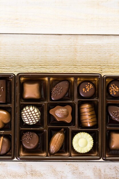 Assorted chocolates on wood table.