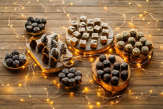 Assorted chocolates on wooden table with garland