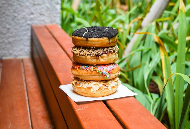 assorted colorful donuts, with assorted toppings of chocolate, nuts, almonds, cheese, strawberries