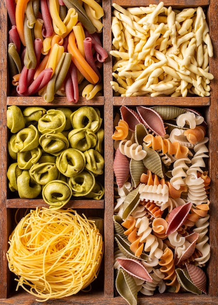 Assorted colorful italian pasta in wooden box