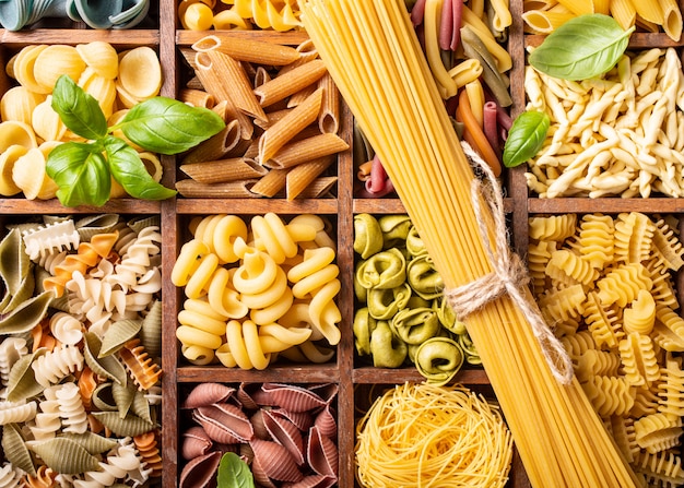 Assorted colorful italian pasta in wooden box