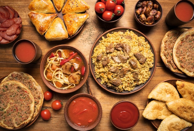 Assorted dishes arabic cuisine uzbek tatar caucasian cuisine pilaf rice soup with beef lagman turkish pizza samsa pasties dates raisins tomatoes dried meat Middle eastern dinner Food party