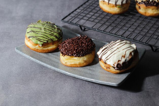 Photo assorted donuts arranged on a tray darkmood photography