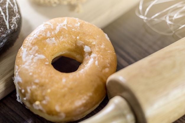 assorted donuts with chocolate frosted, pink glazed and sprinkles donuts on background wood.