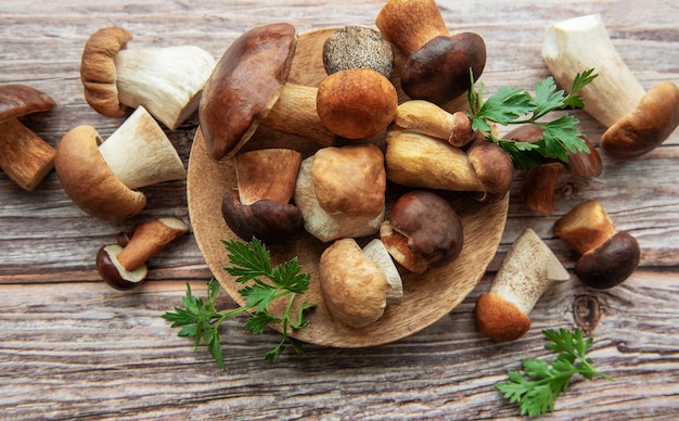 assorted fresh mushrooms and herbs arranged on a wooden board in a rustic kitchen setting