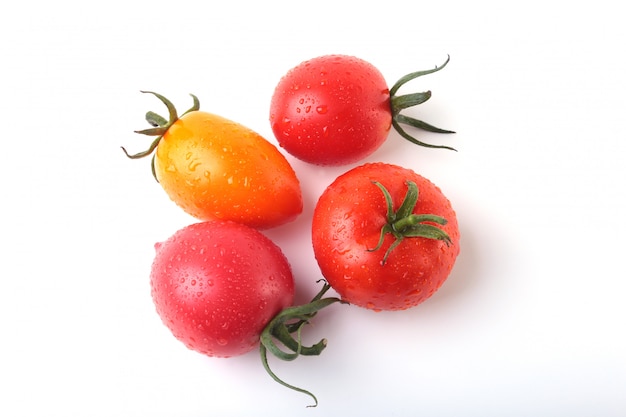 Assorted fresh tomatoes with green leaves.