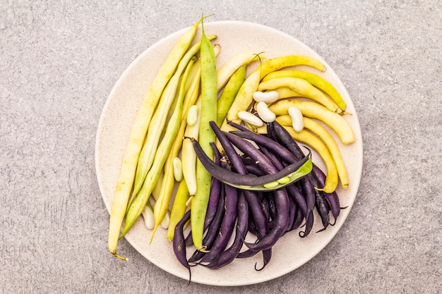 Assorted freshly colored beans in pods