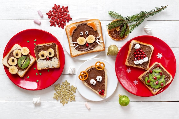 Assorted funny sandwiches on plates, top view. The idea of a menu for a children's party. Creative breakfast, Christmas theme.