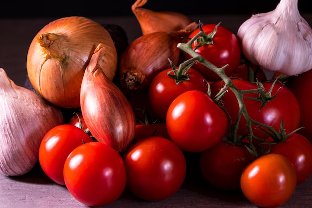 Pomodori e cipolle di aglio assortiti per un manifesto della decorazione della cucina