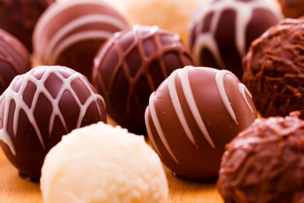 Assorted gourmet truffles on a wooden board.