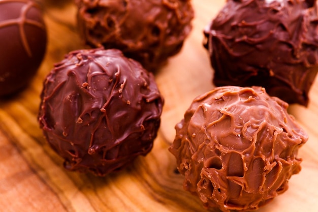 Assorted gourmet truffles on a wooden board.