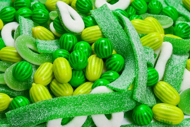 Assorted green gummy candies surface