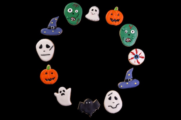 Ассорти из печенья на хэллоуин, образуя круг на черном фоне - вид сверху