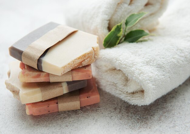 Assorted handmade natural soap bars massage towel and green leaves Spa and massage concept Healthy lifestile