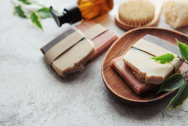 Assorted handmade soap bars and green leaves