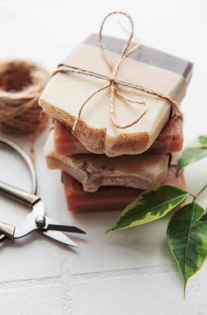 Assorted handmade soap bars and green leaves